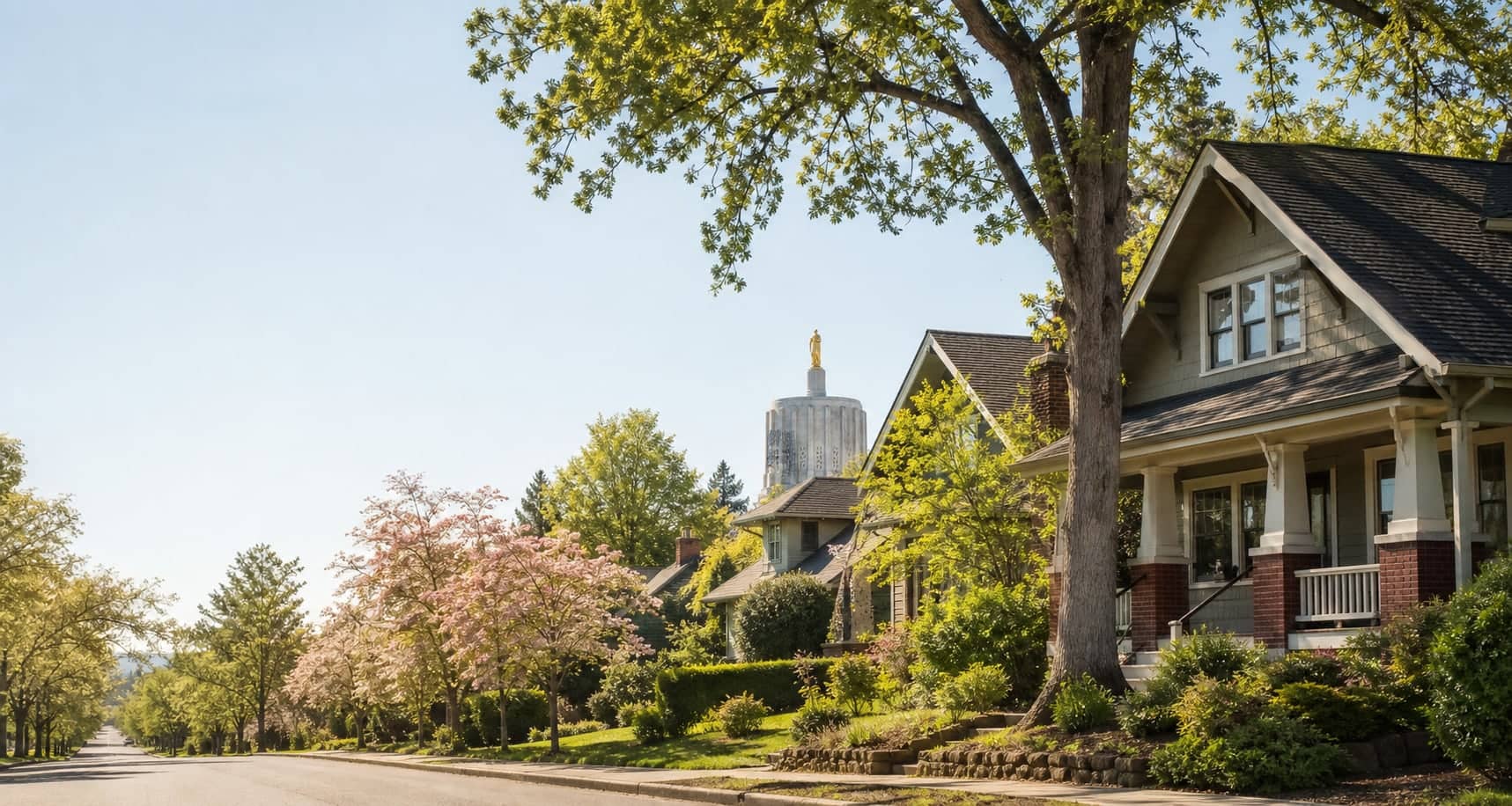 A sunlit Salem heritage neighborhood with Craftsman homes and the Oregon State Capitol beyond.